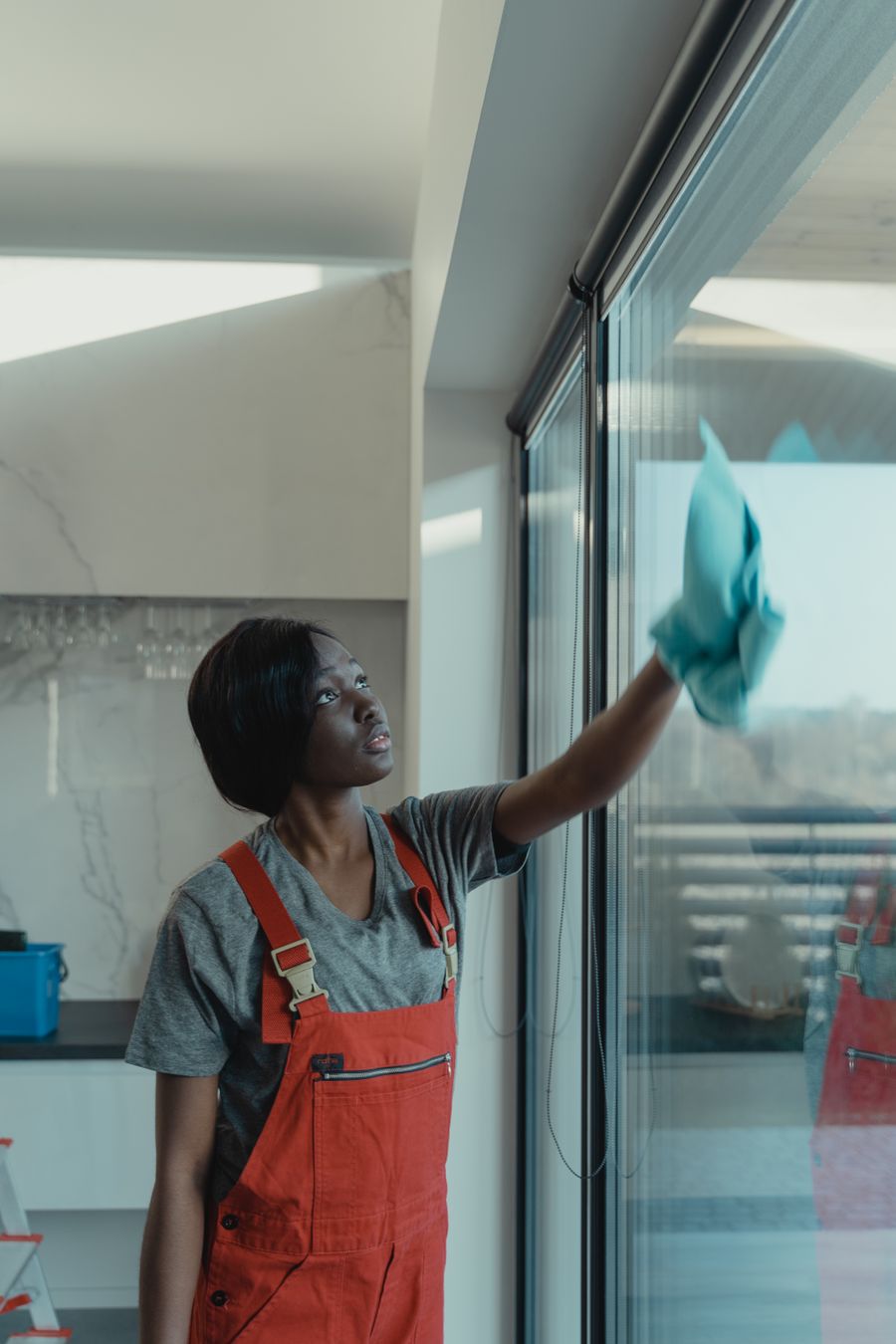 Cleaner cleaning a large glass front in a modern office